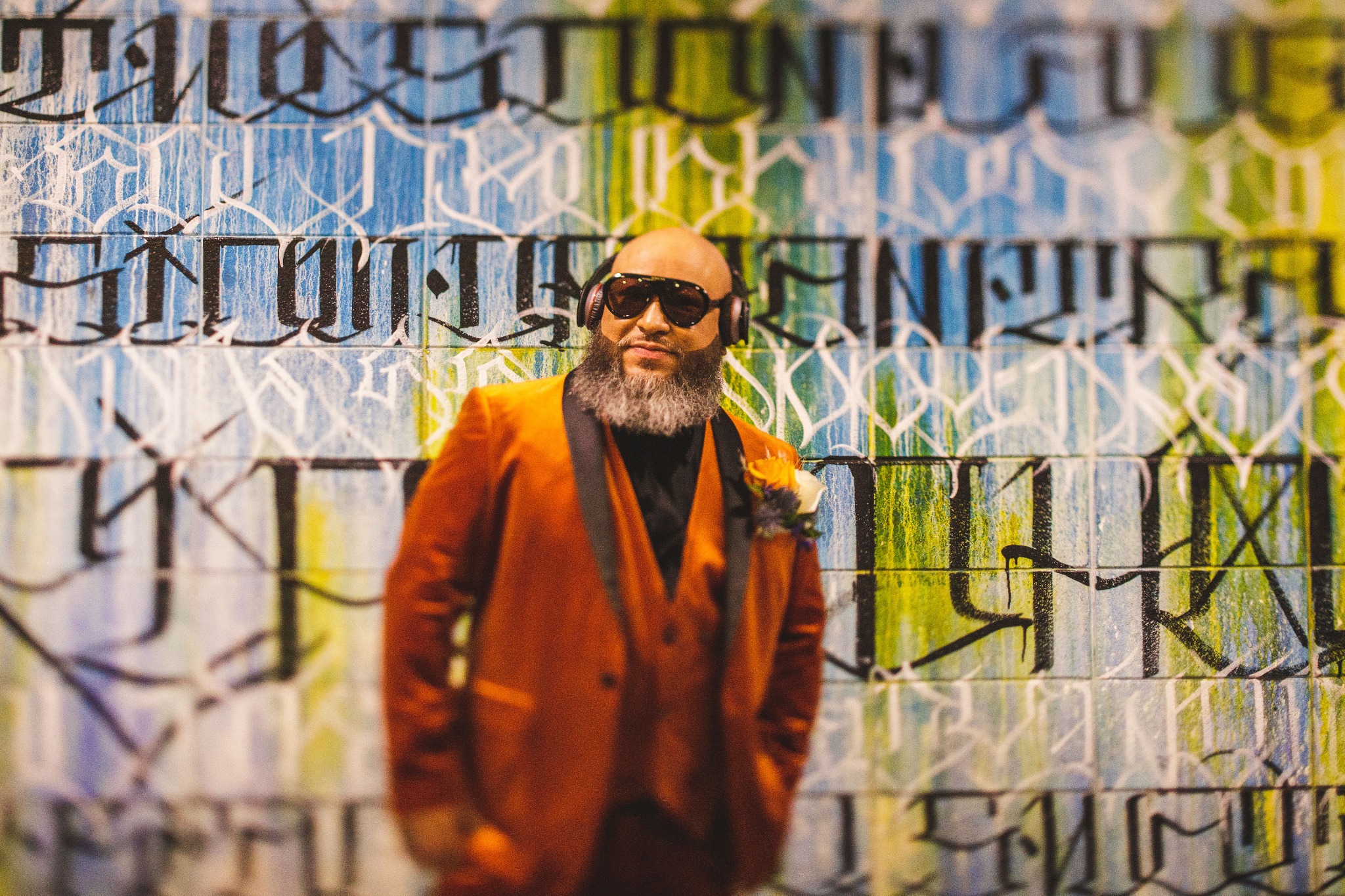 Danny Byers in a rust-colored jacket in front of a colorful mural